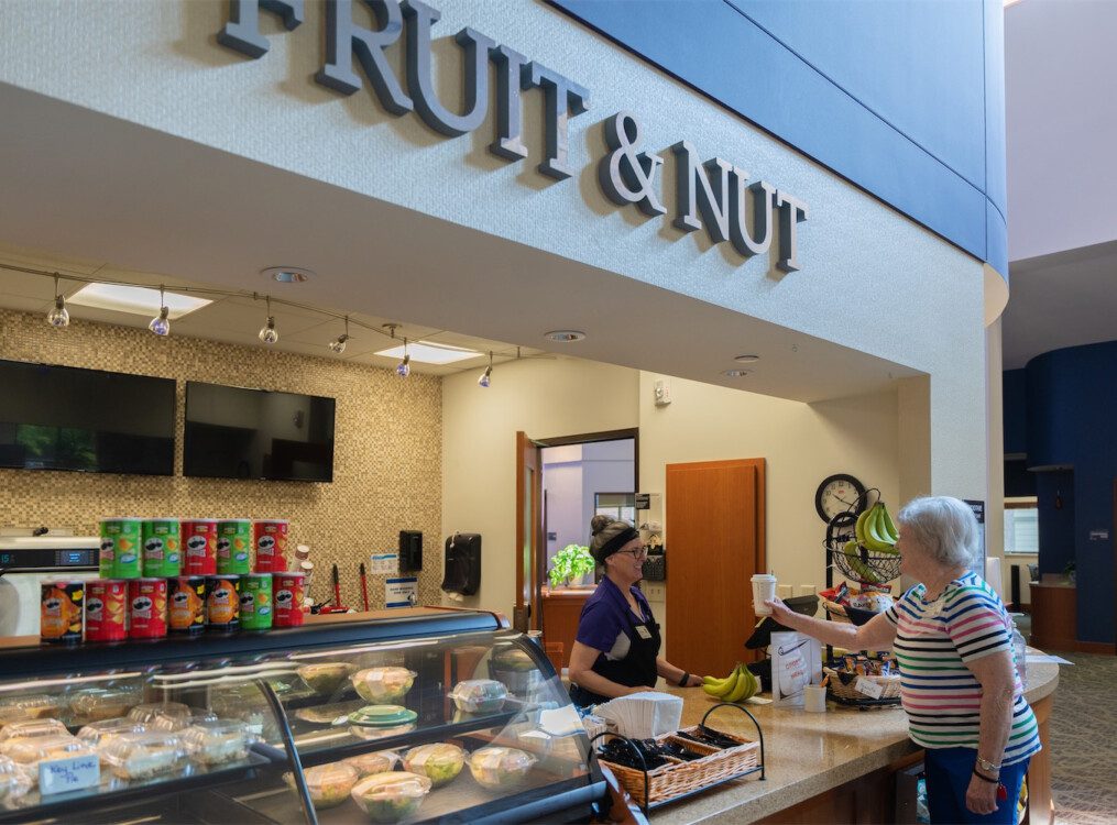 woman purchasing coffee from cafe counter